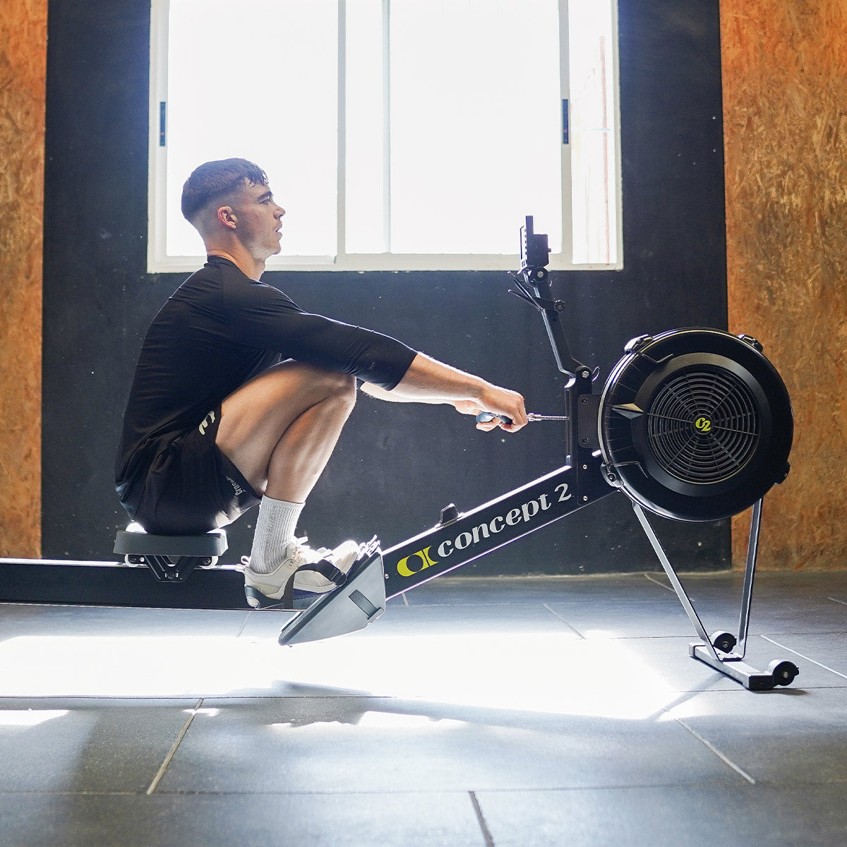 Athlete Calum Clemens training with Velites Minimal 1.0 Ivory White barefoot shoes on Concept2 rowing machine